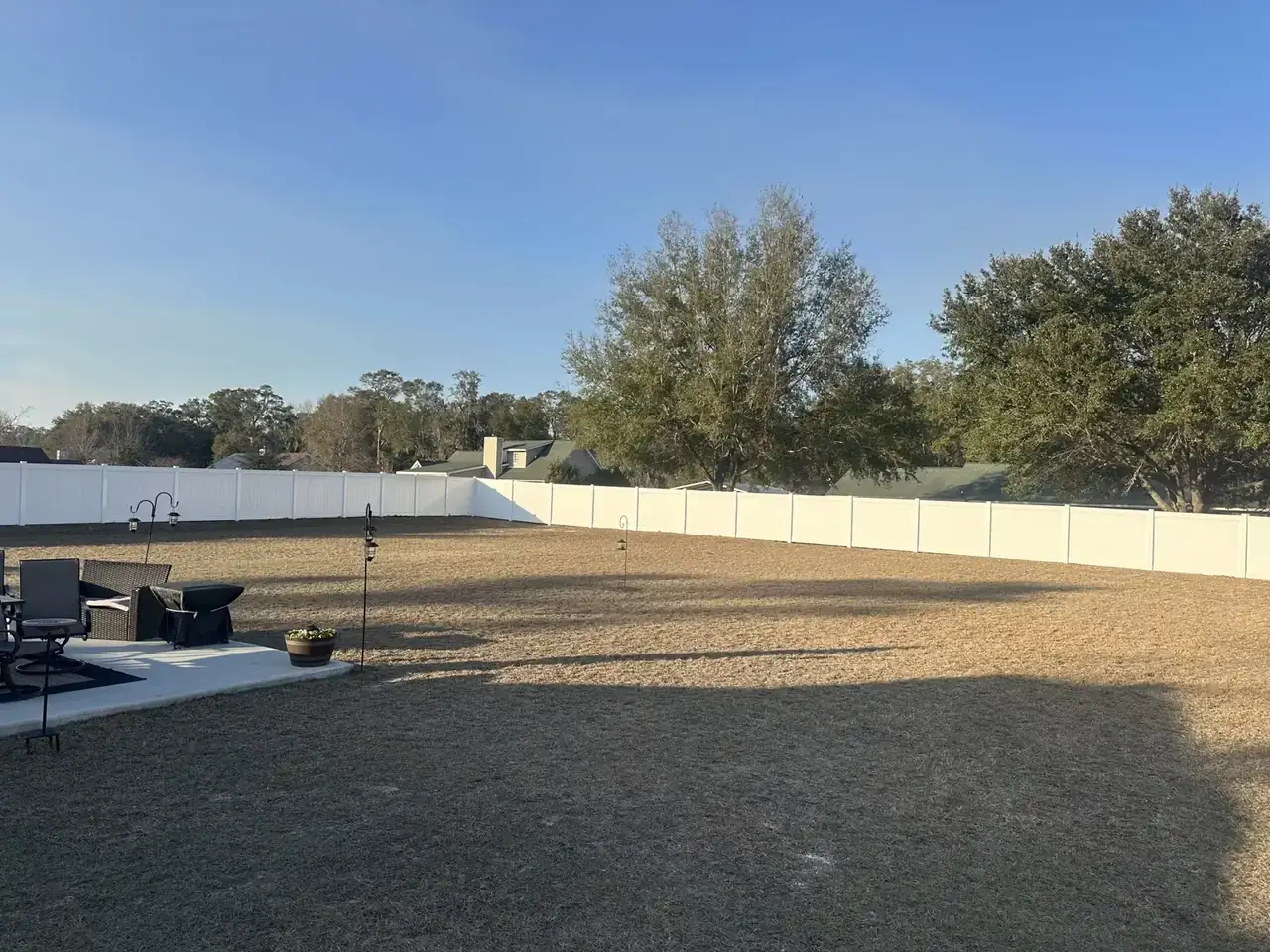White vinyl fence enclosing a large backyard